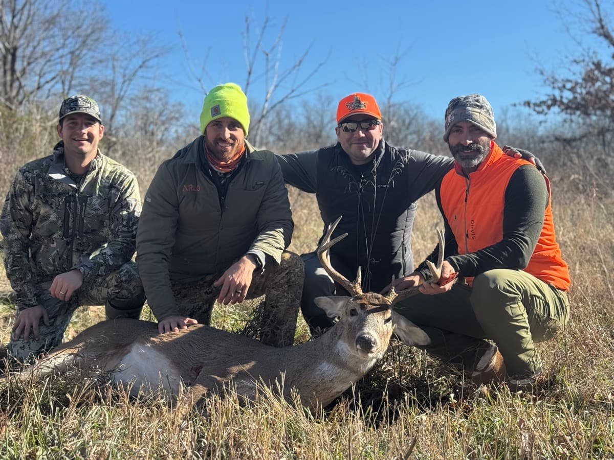 Four guys with a buck after a successful hunt