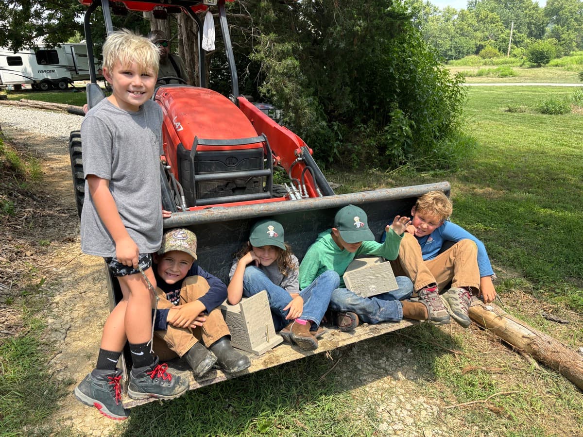 Kids sitting in a tractor bucket